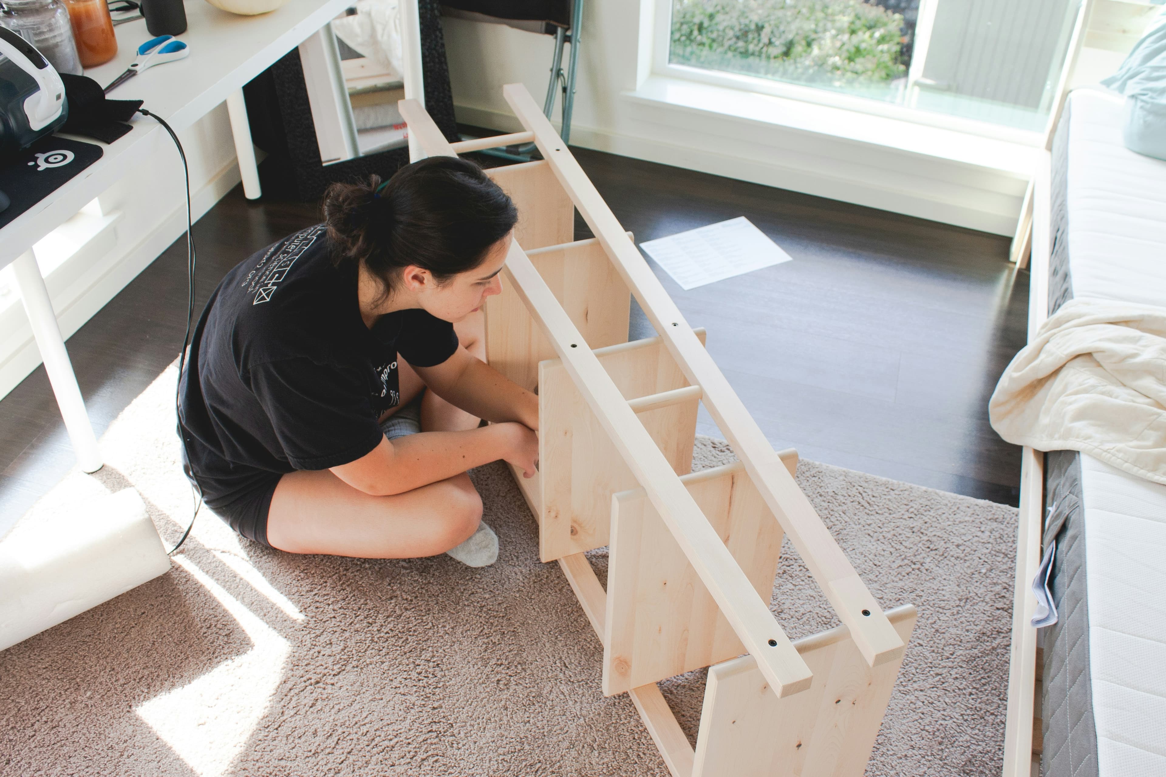 Donna che monta uno scaffale di legno