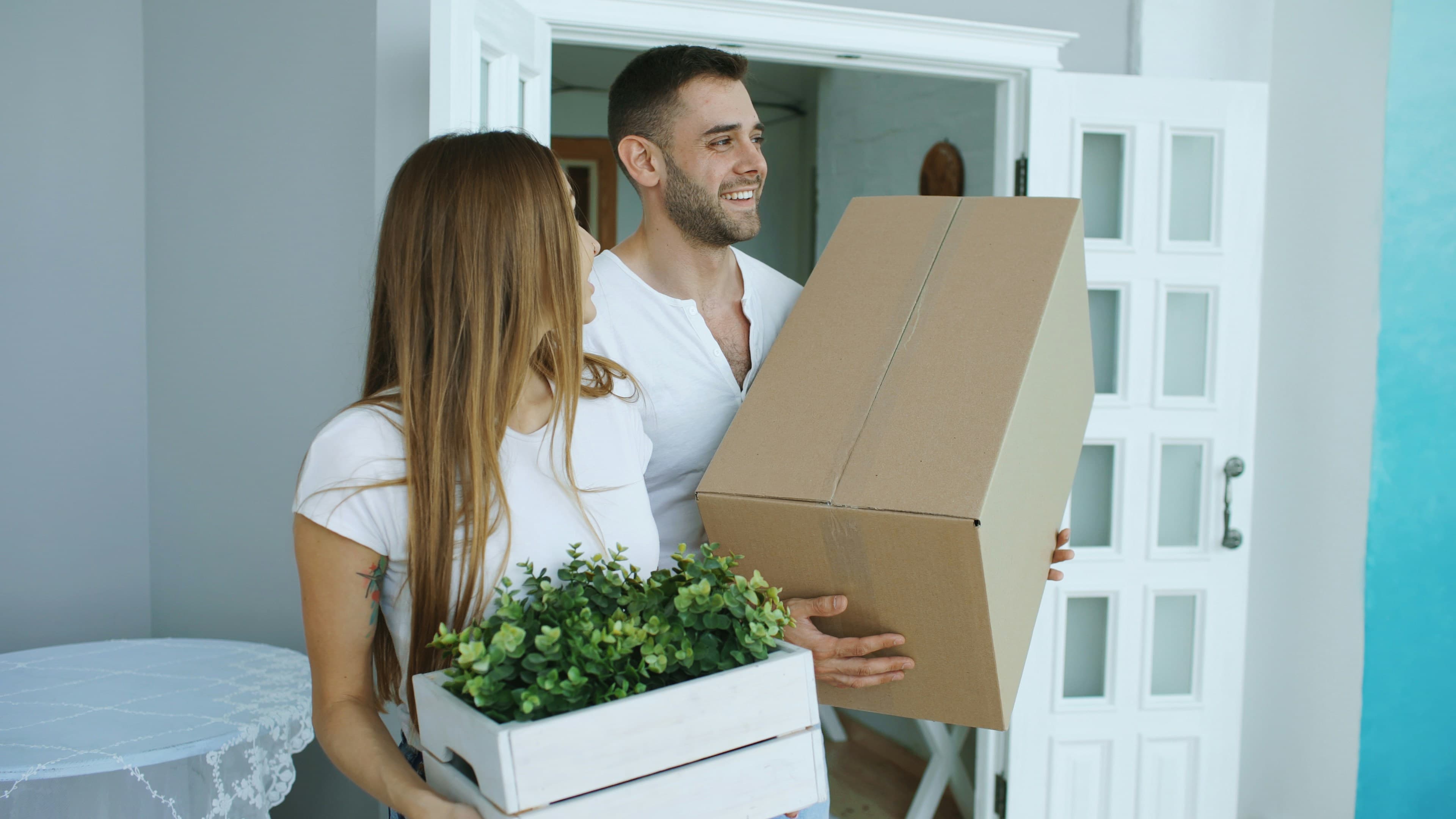 Due persone che portano scatoloni dentro casa